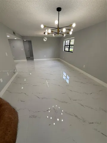 an empty room with windows and ceiling fan