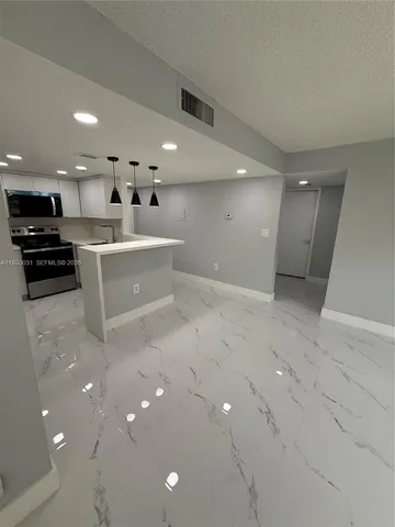 a kitchen with stainless steel appliances a refrigerator a stove a microwave and white cabinets