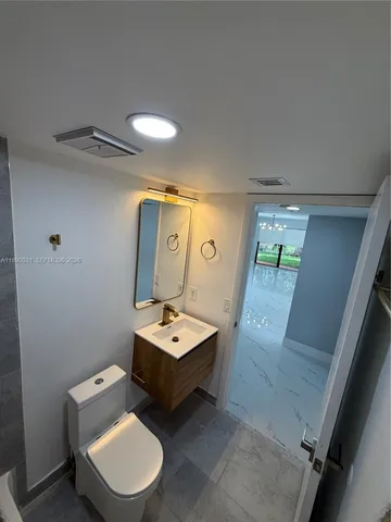 a bathroom with a sink mirror toilet and bathtub