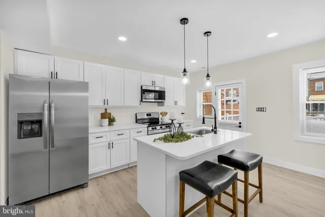 a kitchen that has a lot of cabinets a sink and appliances in it