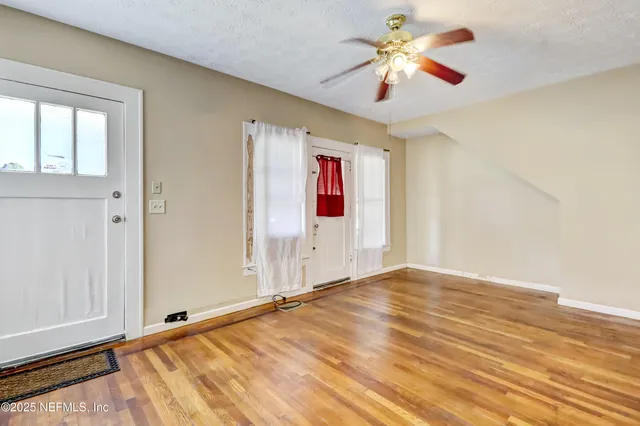 a view of an empty room with wooden floor