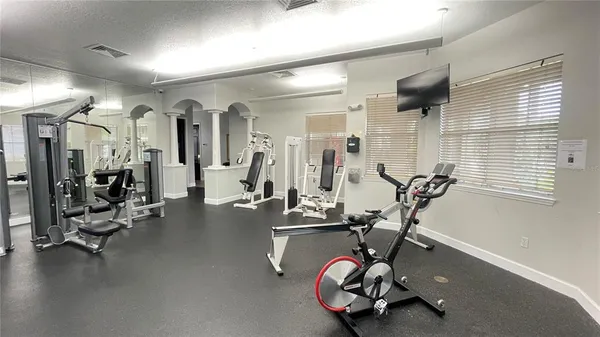 a room with gym equipment and large mirror