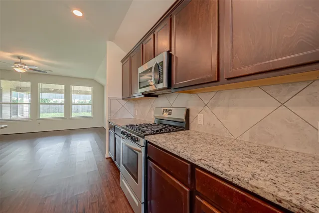 a kitchen with granite countertop wooden cabinets a sink and dishwasher