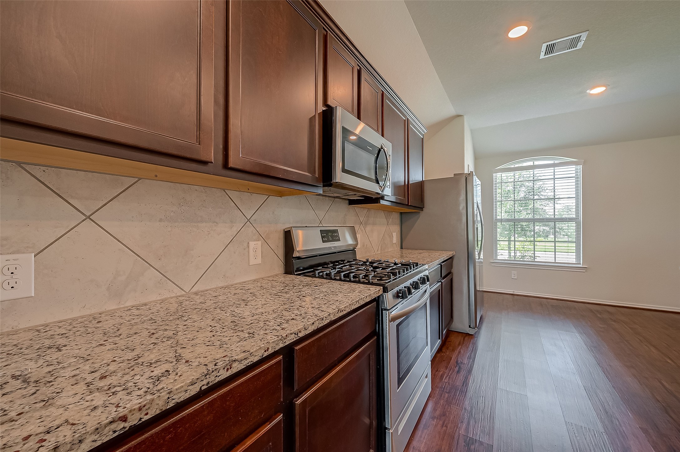 25911 Rustical Road Katy, TX 77493 - Photo 13 of 40 a kitchen with granite countertop wood cabinets stainless steel appliances and a counter space