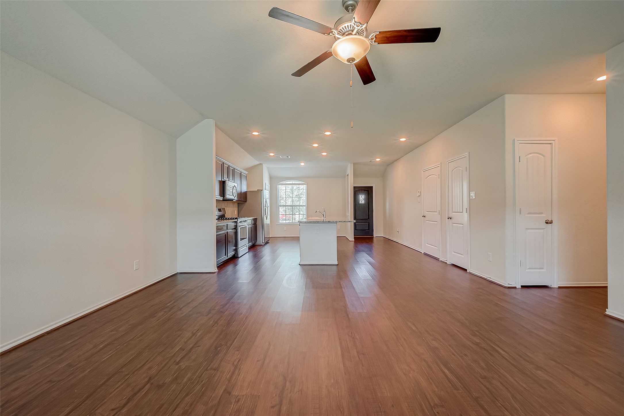 25911 Rustical Road Katy, TX 77493 - Photo 23 of 40 a view of a hallway with wooden floor and a ceiling fan