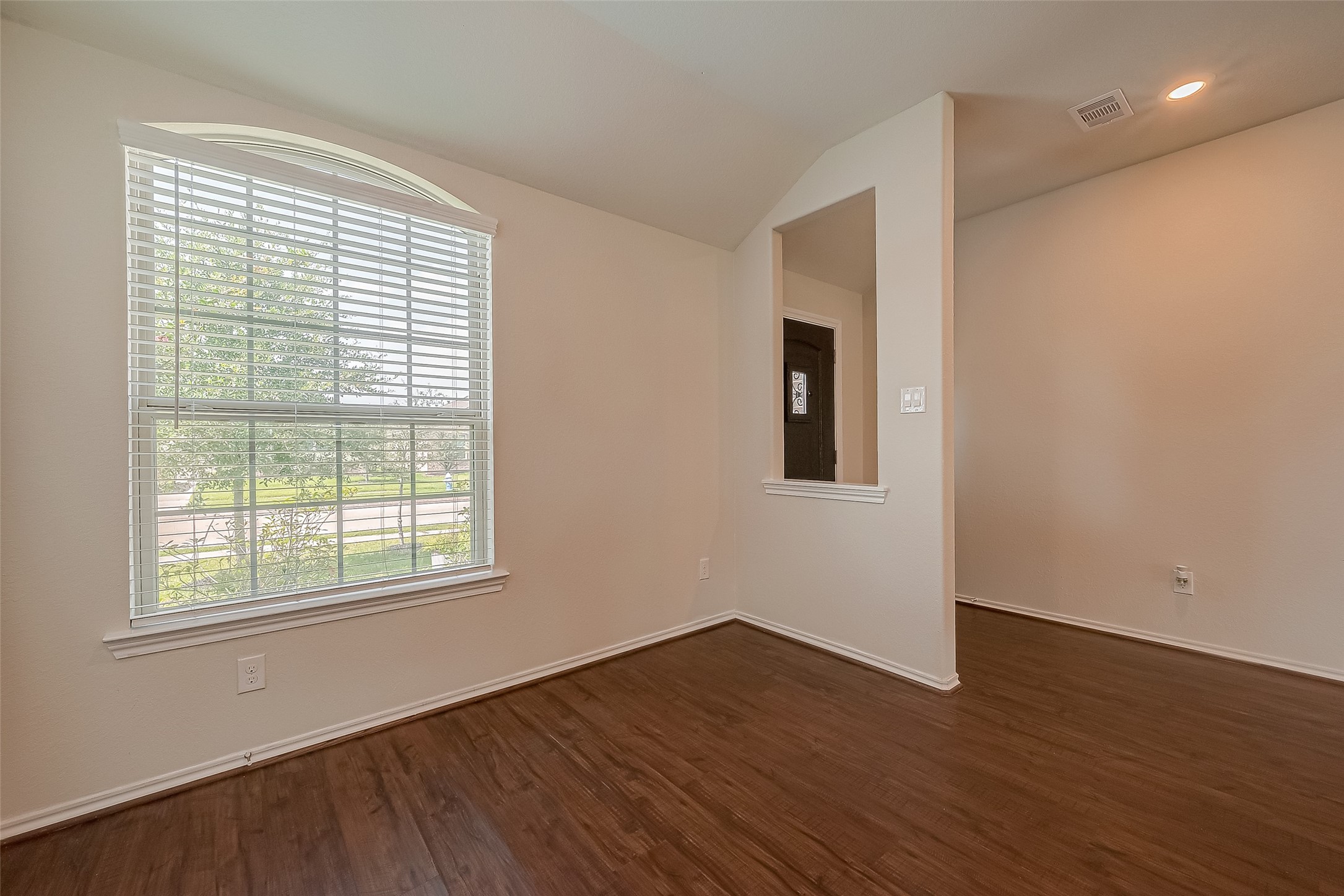 25911 Rustical Road Katy, TX 77493 - Photo 8 of 40 a view of an empty room with wooden floor and a window