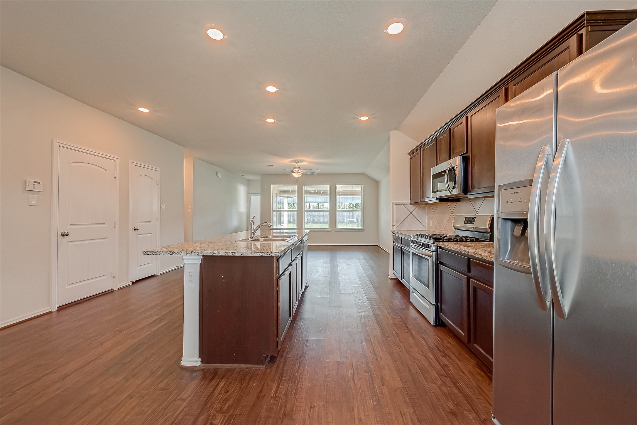 25911 Rustical Road Katy, TX 77493 - Photo 9 of 40 a living room with stainless steel appliances granite countertop a refrigerator a sink dishwasher a stove and a dining table with wooden floor