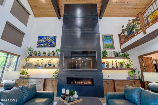 a living room with furniture a fireplace and a large window