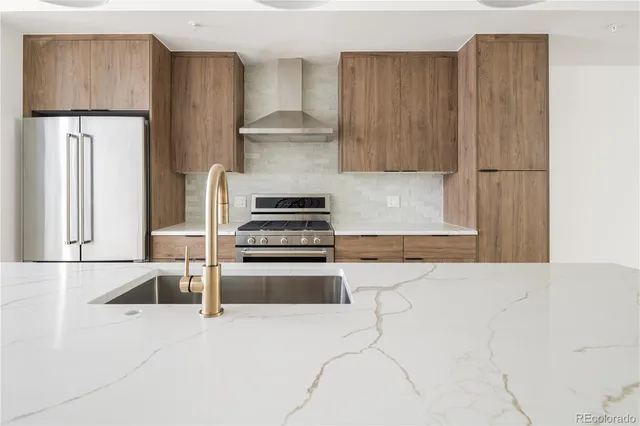a kitchen with stainless steel appliances a refrigerator and a stove top oven