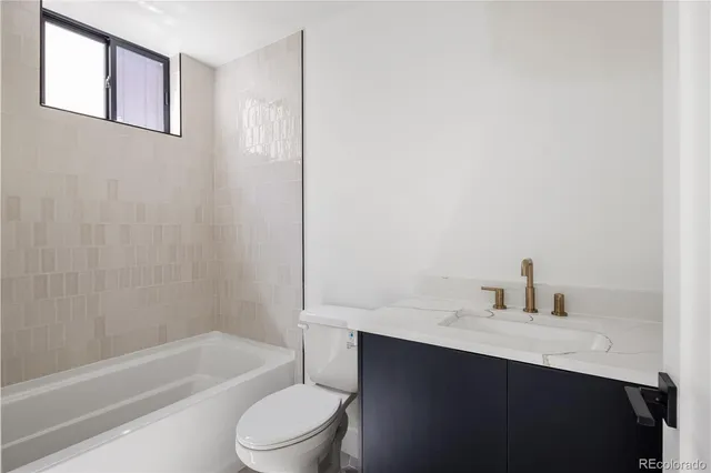 a bathroom with a sink toilet vanity and bathtub
