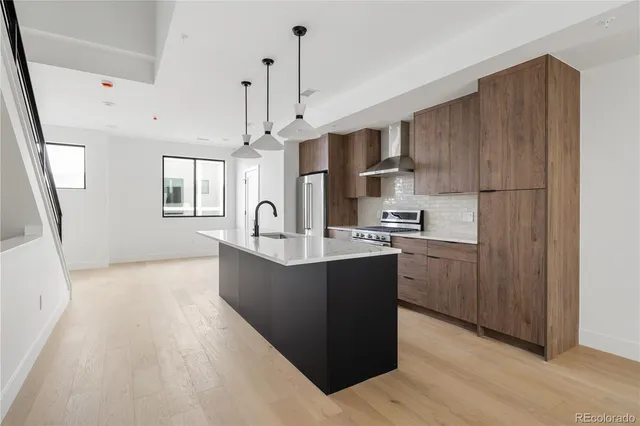 a kitchen with kitchen island a sink a center island stainless steel appliances and a window