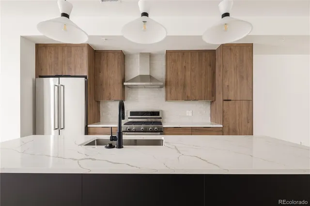 a kitchen with kitchen island a stove a refrigerator and wooden floor