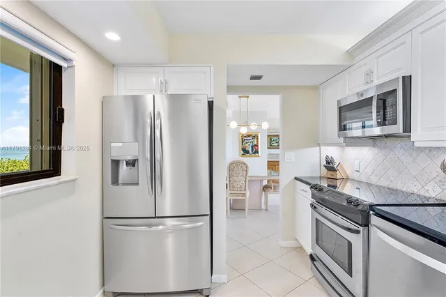 a kitchen with stainless steel appliances granite countertop a refrigerator stove microwave and sink