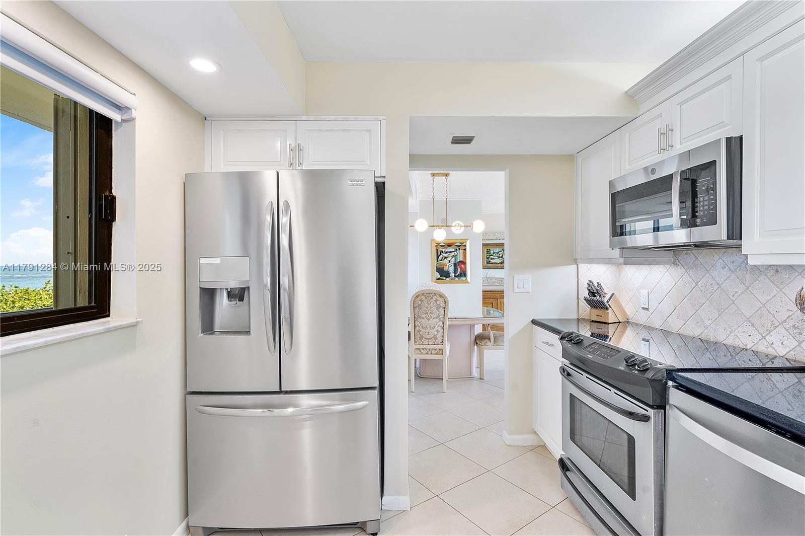 400 Ocean Trail Way, Unit 302 Jupiter, FL 33477 - Photo 11 of 34 a kitchen with stainless steel appliances granite countertop a refrigerator stove microwave and sink