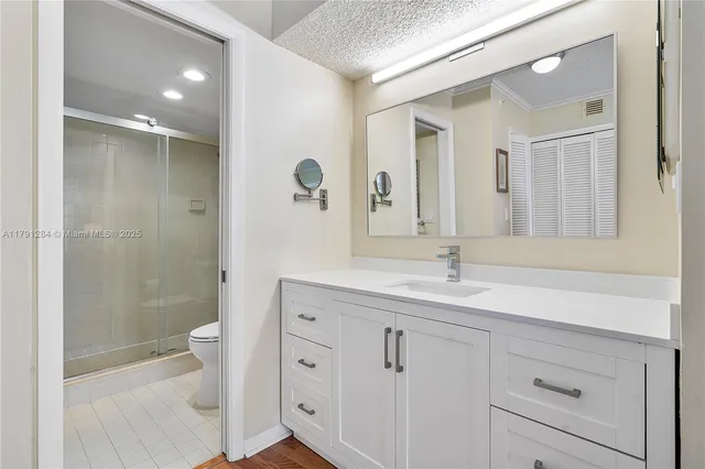a bathroom with a double vanity sink toilet and shower