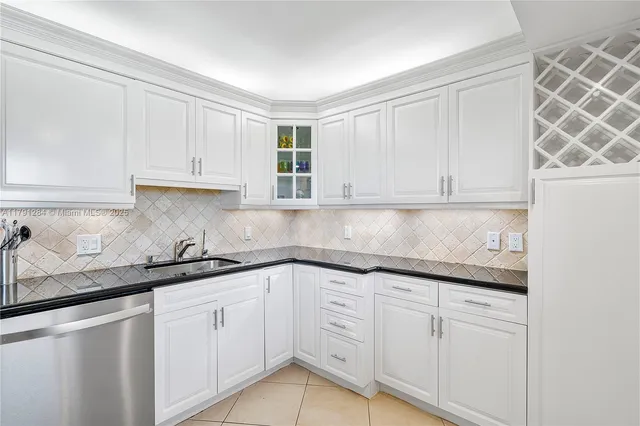 a kitchen with granite countertop white cabinets and white appliances