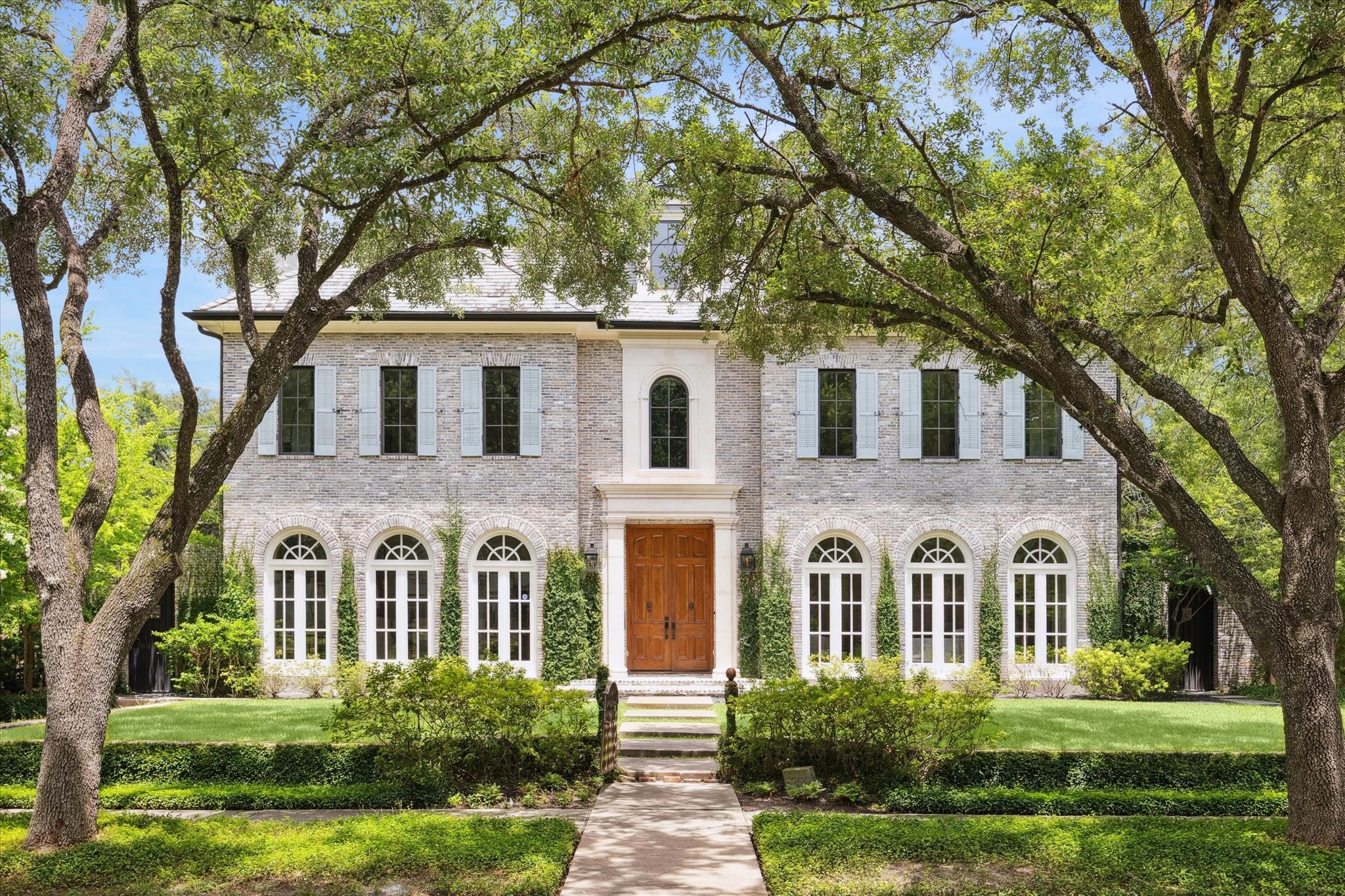 a front view of a house with yard and green space