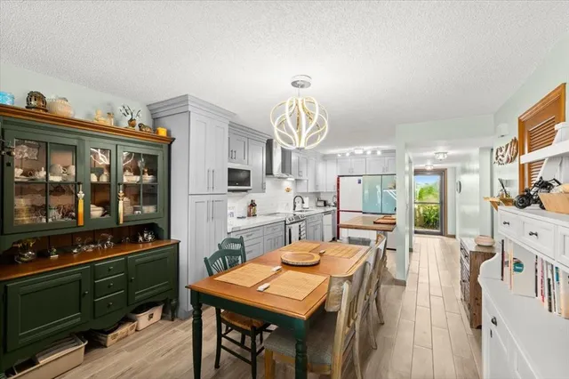 a kitchen with stainless steel appliances a dining table and chairs