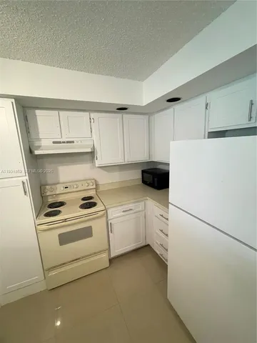 a kitchen with white cabinets and white stainless steel appliances