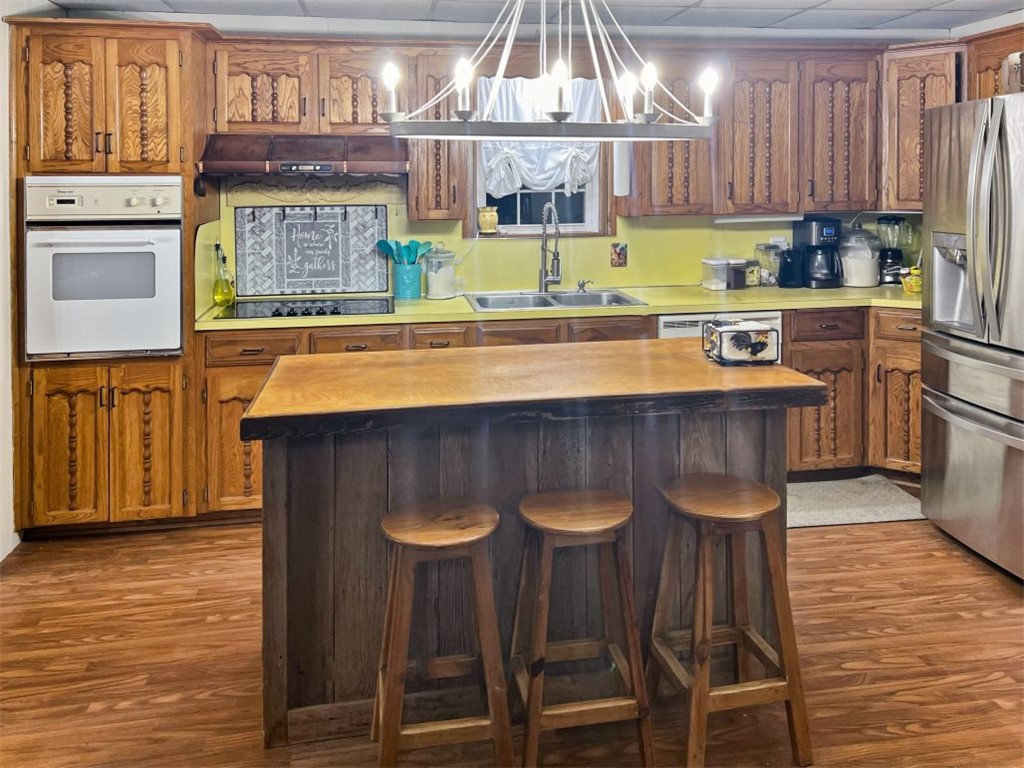 1188 Private 6030 Cameron, TX 76520 - Photo 7 of 28 Kitchen featuring dark wood-style flooring, a sink, stainless steel refrigerator with ice dispenser, white oven, and black electric stovetop