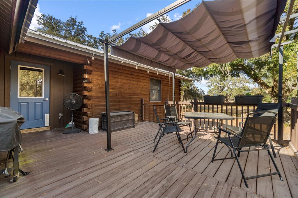 4292 Southwest 73rd Trail Bushnell, FL 33513 - Photo 43 of 88 a view of a patio with table and chairs with wooden floor and fence