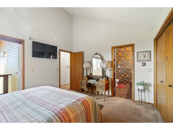 a bedroom with a bed a flat screen tv and dresser
