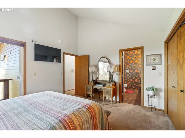 a bedroom with a bed a flat screen tv and dresser