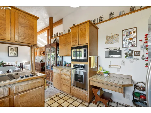 a kitchen view with stainless steel appliances kitchen island granite countertop a refrigerator and a stove top oven