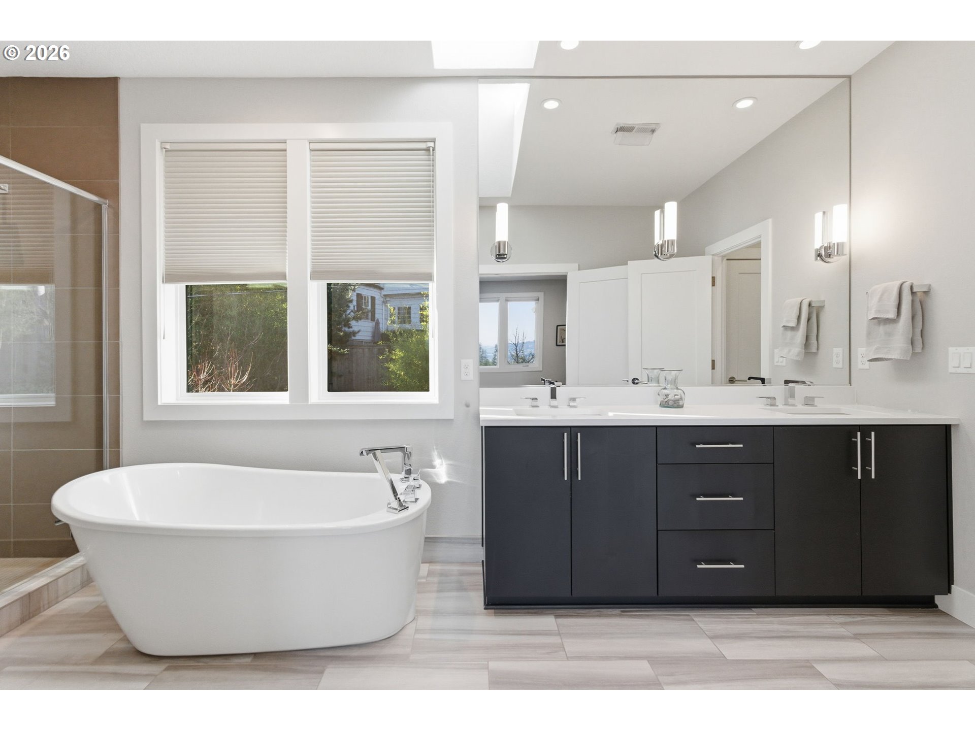 2123 South Military Road Portland, OR 97219 - Photo 28 of 47 a bathroom with a tub a double vanity sink a mirror and a window
