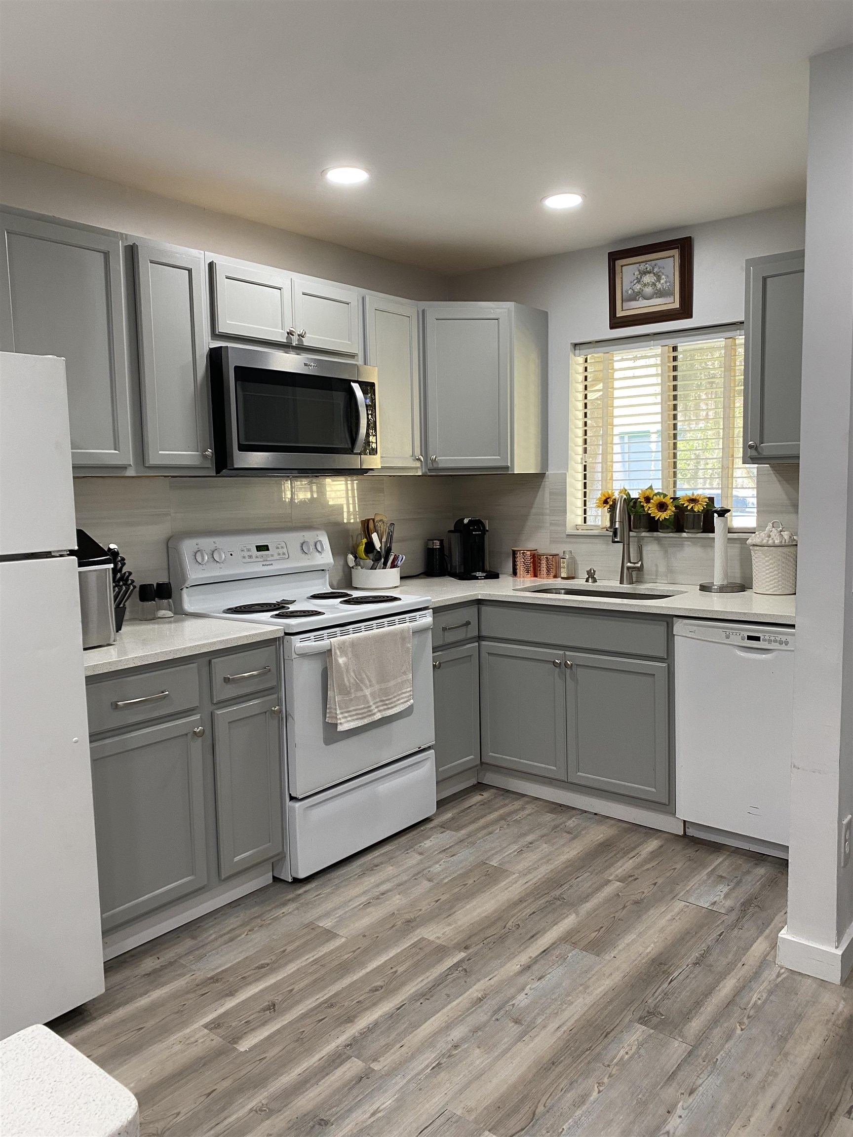 a kitchen with a sink white cabinets and stainless steel appliances