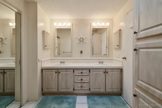 a bathroom with a granite countertop sink two mirror and a