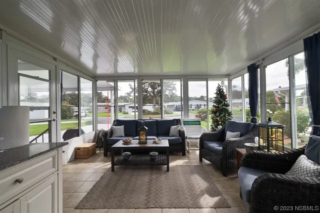 a living room with furniture and a floor to ceiling window