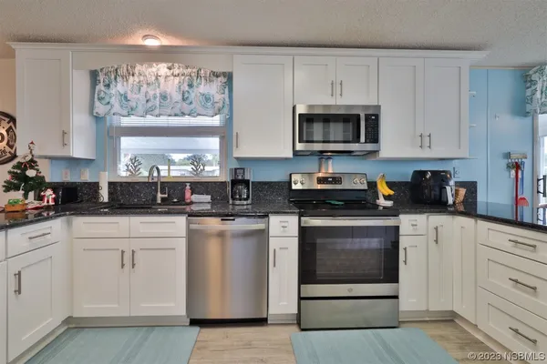 a kitchen with white cabinets and white appliances