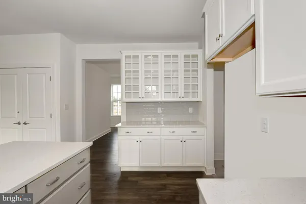 a kitchen with a sink dishwasher a stove and white cabinets with wooden floor