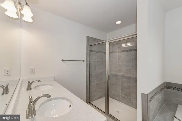 a bathroom with a sink vanity mirror and shower