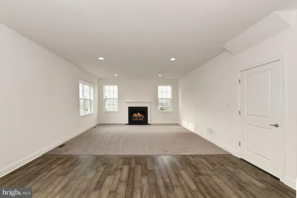 an empty room with wooden floor and fireplace