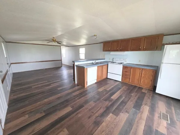 a kitchen with granite countertop a refrigerator and a stove top oven