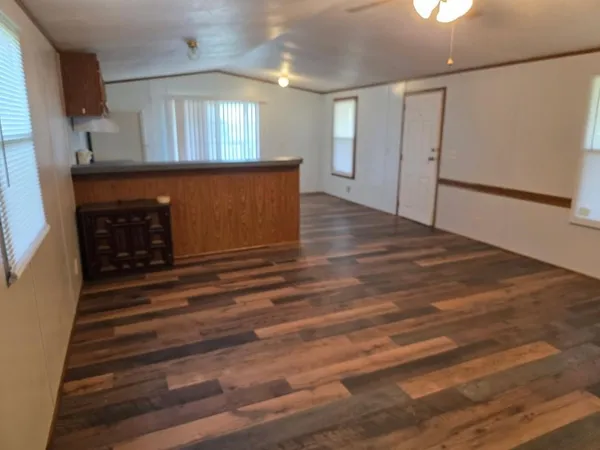 a view of a livingroom with wooden floor and a fireplace