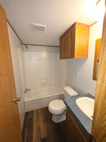 a bathroom with a granite countertop sink toilet and shower