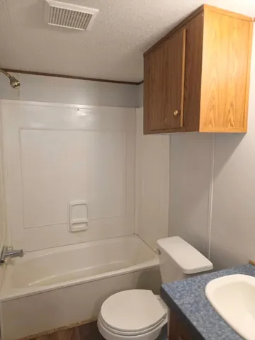 a bathroom with a toilet a sink and bathtub