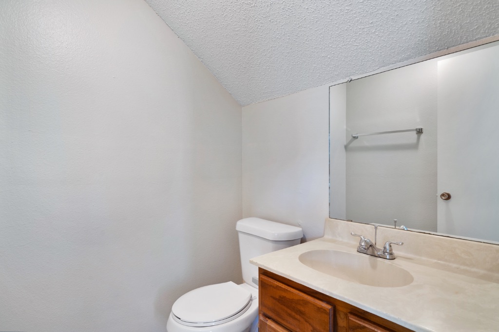 8703 Schick Road, Unit C Austin, TX 78729 - Photo 14 of 24 a bathroom with a sink toilet and a mirror