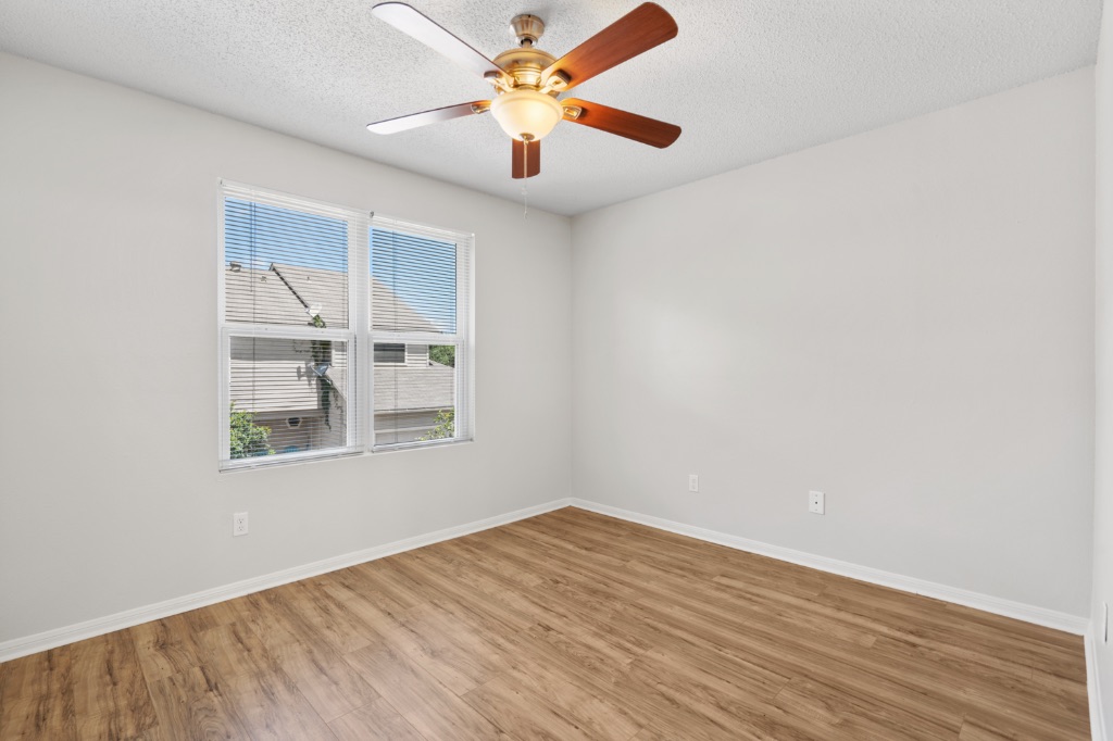 8703 Schick Road, Unit C Austin, TX 78729 - Photo 15 of 24 an empty room with wooden floor and windows
