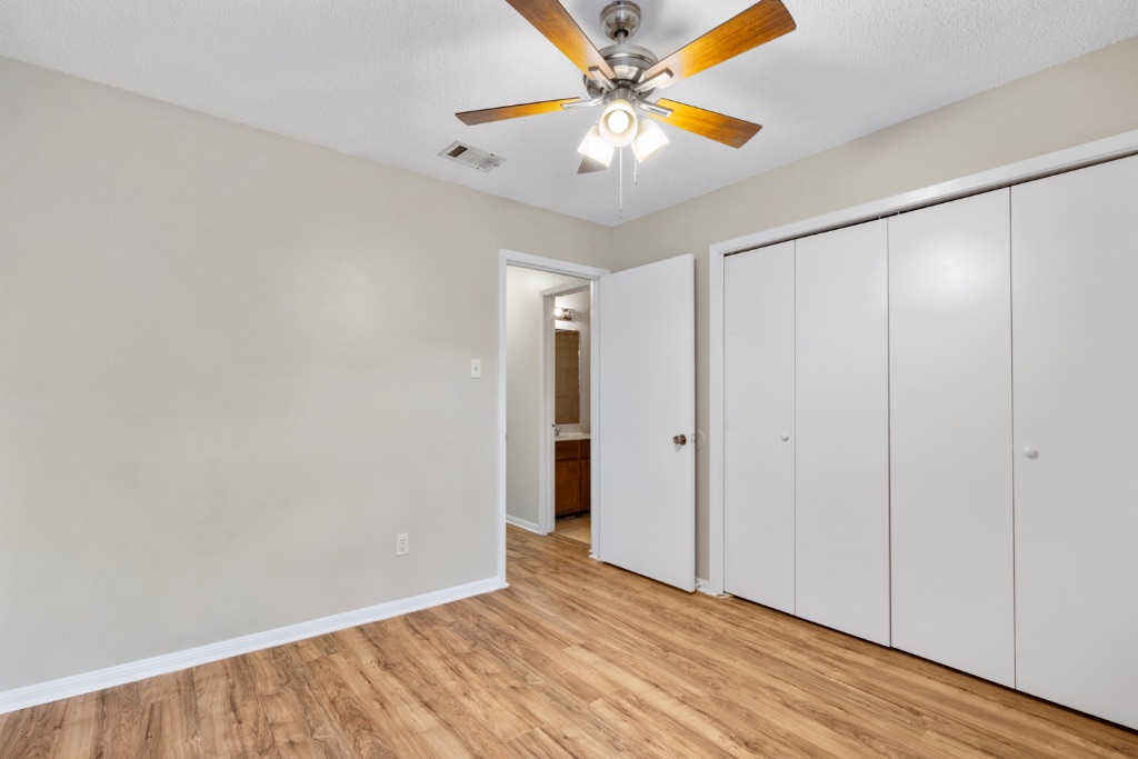 8703 Schick Road, Unit C Austin, TX 78729 - Photo 20 of 24 a view of an empty room with window and a ceiling fan