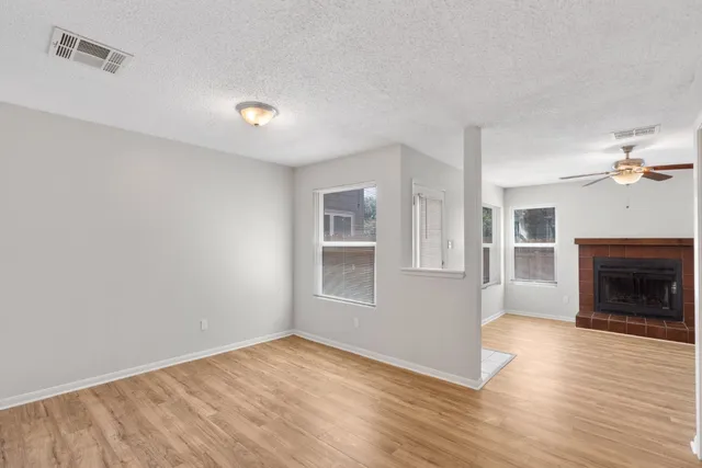 a view of empty room with wooden floor and fireplace