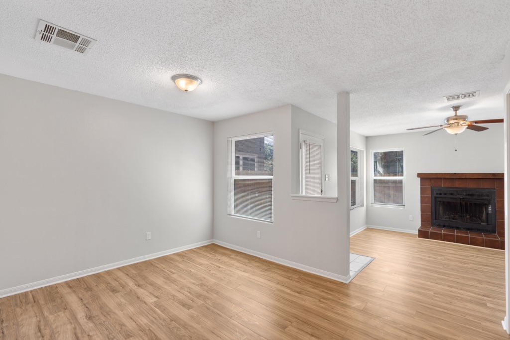 8703 Schick Road, Unit C Austin, TX 78729 - Photo 2 of 24 a view of empty room with wooden floor and fireplace