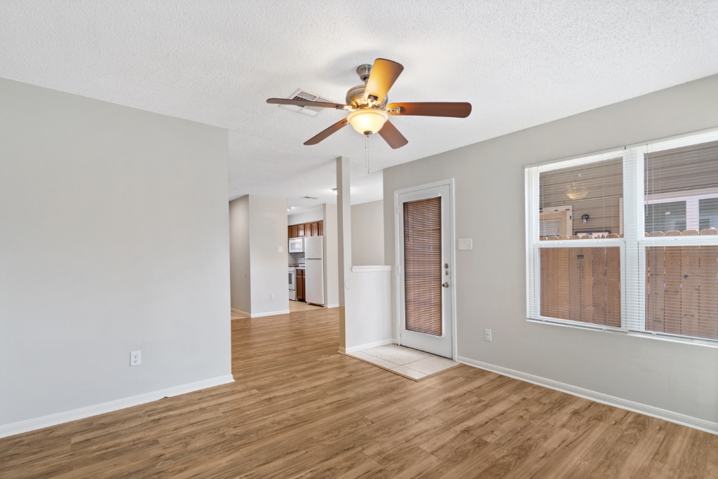 8703 Schick Road, Unit C Austin, TX 78729 - Photo 10 of 24 a view of an empty room with window and wooden floor