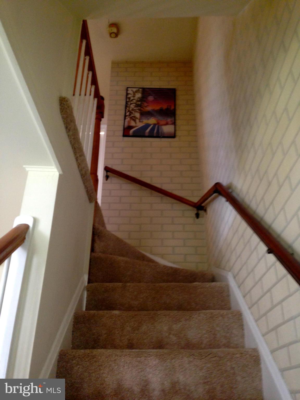 2739 Kirkleigh Road Baltimore, MD 21222 - Photo 14 of 30 a view of staircase with white walls and a painting on the wall