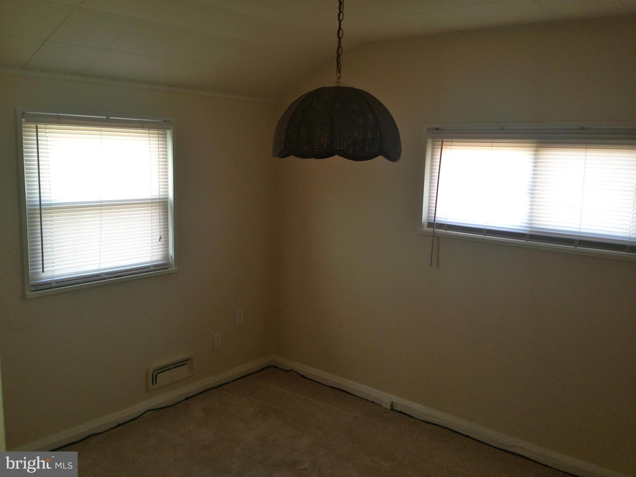 2739 Kirkleigh Road Baltimore, MD 21222 - Photo 17 of 30 a room with a window and a wooden floor