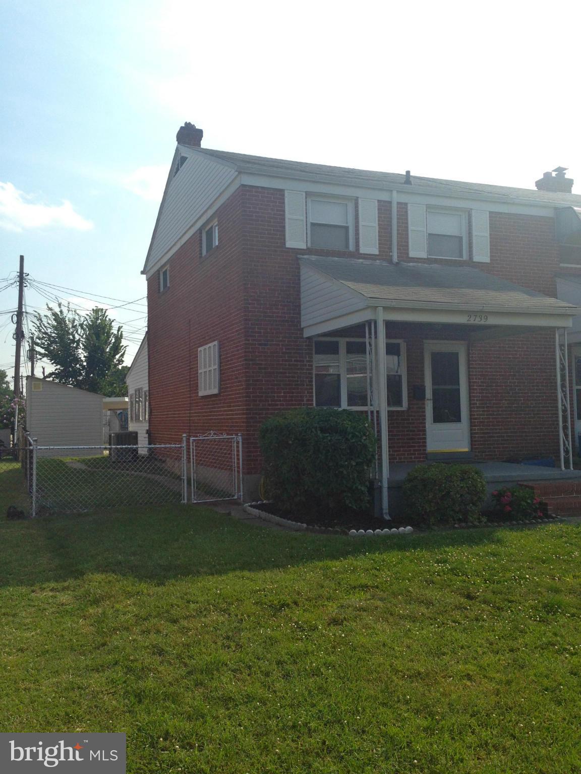 2739 Kirkleigh Road Baltimore, MD 21222 - Photo 2 of 30 a brick house next to a yard with large trees