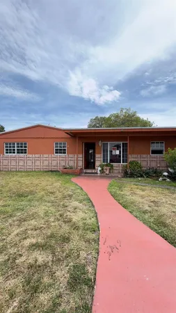 front view of a brick house with a yard